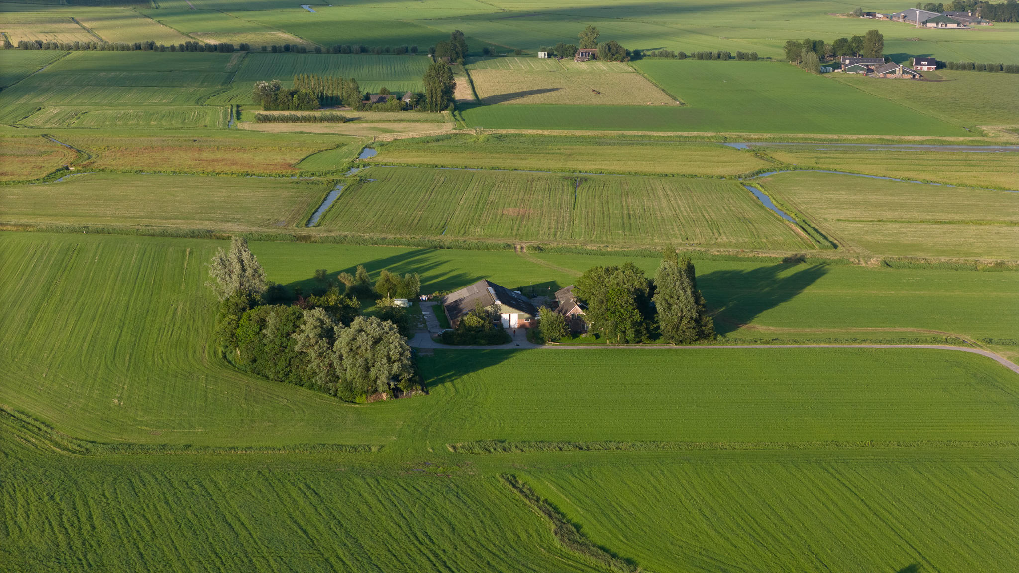 Luchtfoto van Zorgboerderij De Bijenhof in Kollum, omgeven door groene velden en natuurlijke omgeving in Friesland